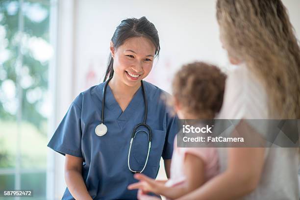 Nurse Speaking To A Mother And Child Stock Photo - Download Image Now - Nurse, Child, Patient