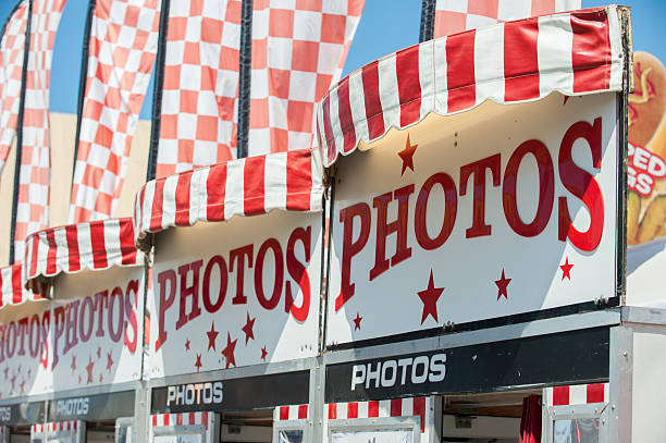 Large signs and flags to attract the customer Row of photo booths at the country fair. midway fair stock pictures, royalty-free photos & images