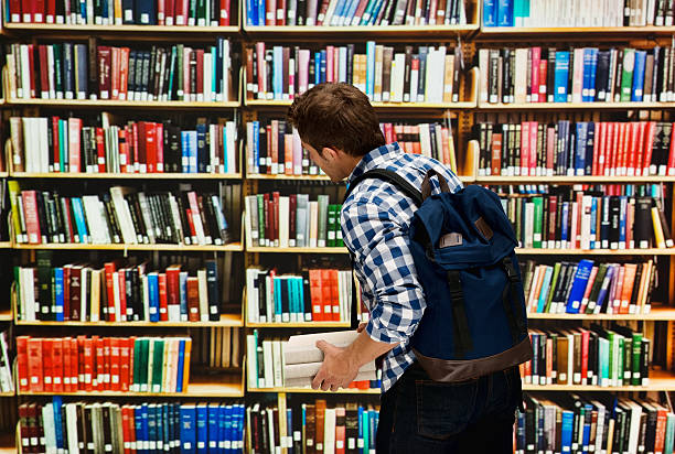 istock Rear view of student standing in library 587955202