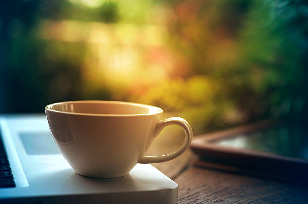 istock Laptop tablet and white coffee cup on wooden table 587955500