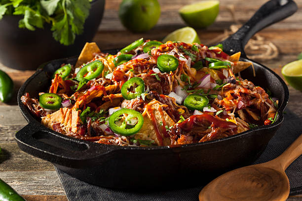 Homemade Barbecue Pulled Pork Nachos Homemade Barbecue Pulled Pork Nachos with Cheese and Peppers nacho chip photos stock pictures, royalty-free photos & images