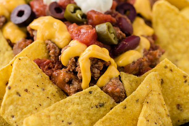 istock Beef nachos with  jalapeno, olives, tomato, beans cheddar cheese 588216702