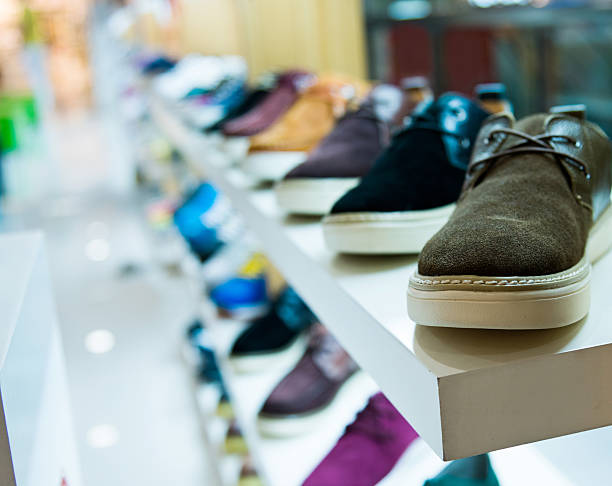 chaussures pour hommes en vente exposées dans un magasin - department store clothing showroom people photos et images de collection