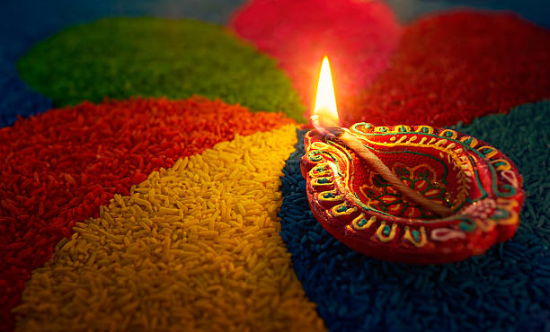 Diwali oil lamp Diwali oil lamp - Diya lamp lit on colorful rangoli diwali photos stock pictures, royalty-free photos & images