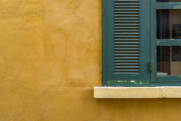 istock Green glass window on yellow wall 588224144