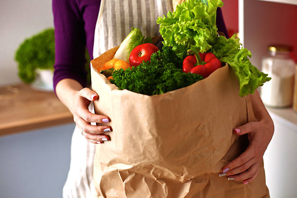 istock Young woman cutting vegetables in the kitchen 588225210