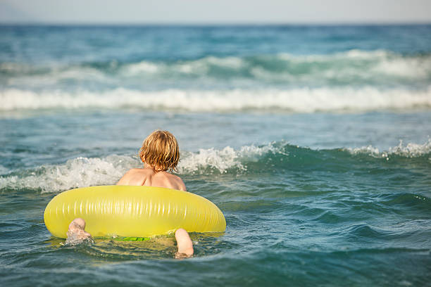 istock Boy in inflatable ring having fun, swimming 588225400