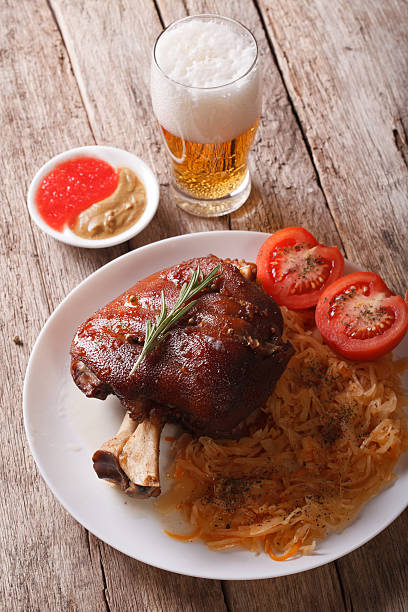 istock eisbein: baked pork shank and braised cabbage and beer. vertical 588228766