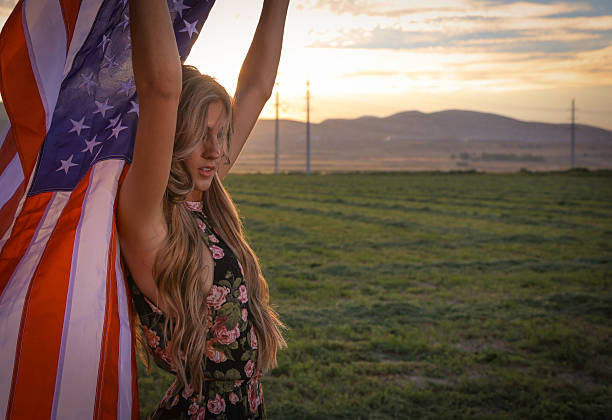 istock Woman with in field with american flag 588231054