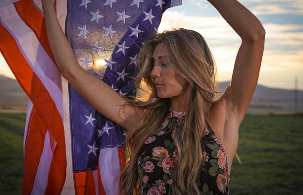 istock Woman with in field with american flag 588231144