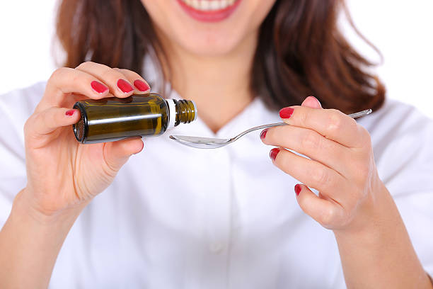 istock nurse taking medicine drops on a spoon 588232244