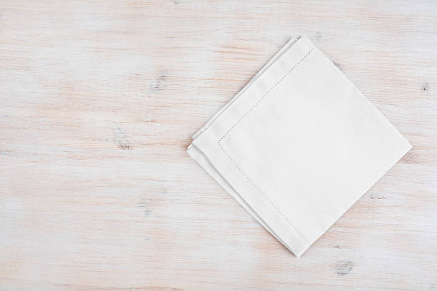 Clean folded linen napking on wooden texture background with copyspace