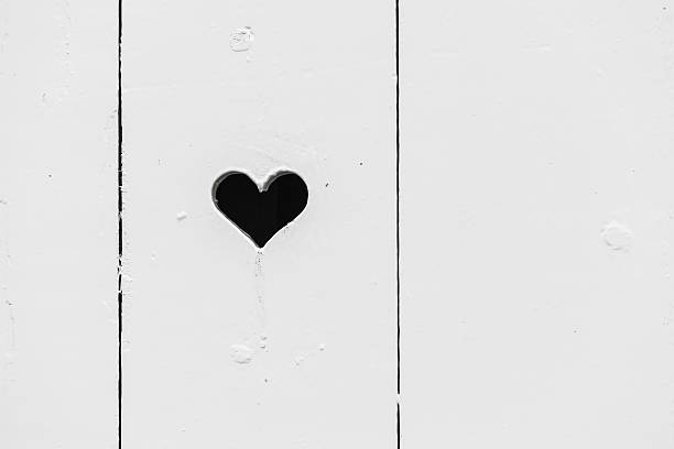istock Heart shaped hole in white wooden wall 588243534