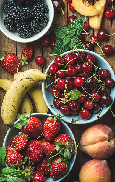 istock Summer fresh fruit and berry variety over wooden backdrop 588248954
