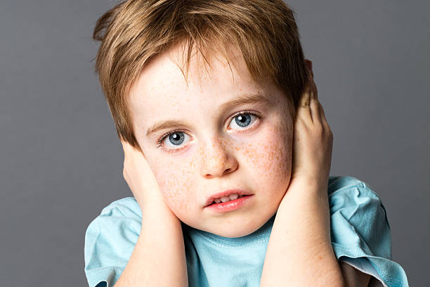 istock scared young boy suffering from domestic violence covering his ears 588254012