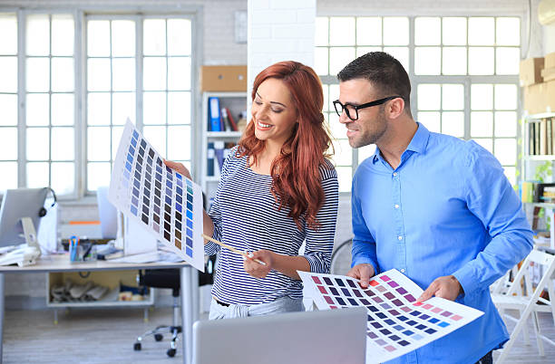 istock Two young graphic designers looking at color schemes 588256312
