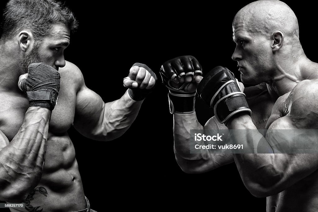 Fight Two muscular guys fighting in front of black background Boxing - Sport Stock Photo