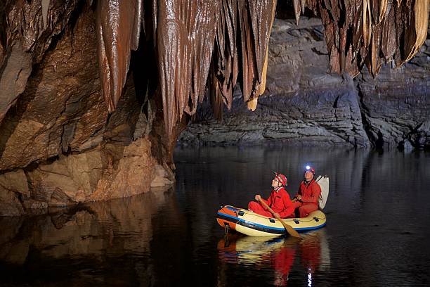 Stalactite in cave Geologist exploring caves on yellow rubber boat. geologist stock pictures, royalty-free photos & images