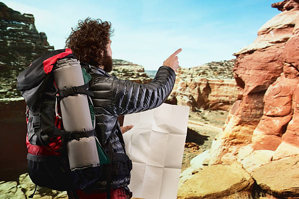 istock Rear view of hiker in mountain and pointing 588258632