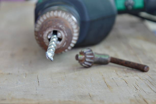 istock electric drill and chuck key on wooden board 588258824