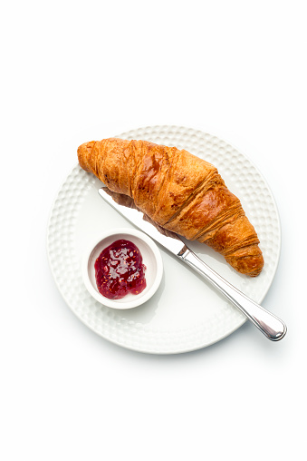 continental breakfast,croissant and Marmalade on a white plate , isolated on white.