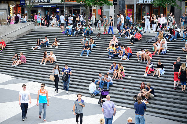 People on city square Sergels Torg, Stockholm Stockholm, Sweden - August 2, 2014: Crowd in stairs. Popular resting and meeting place for shoppers, commuters or any pedestrians downtown Stockholm. The major stairs of Sergels Torg, famous landmark next to the subway entrance. stockholm town square sergels torg sweden stock pictures, royalty-free photos & images