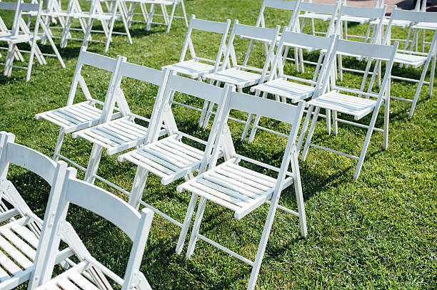 istock Rows of white folding chairs on lawn 588259692