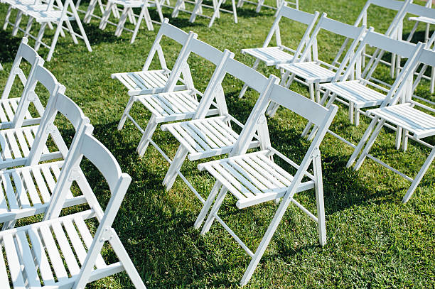 istock Rows of white folding chairs on lawn 588259726