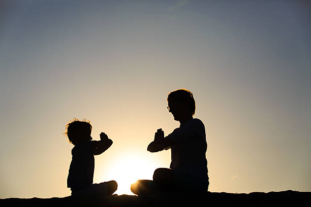 istock father and son doing yoga at sunset 588260878