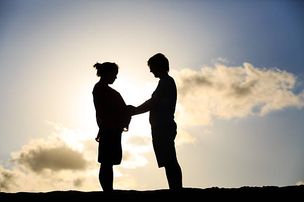 istock happy pregnant couple at sunset beach 588260984