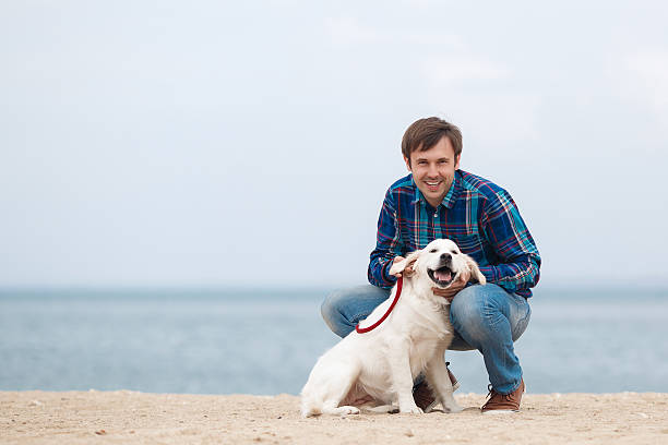 istock Man and dog having fun on seaside. 588265230