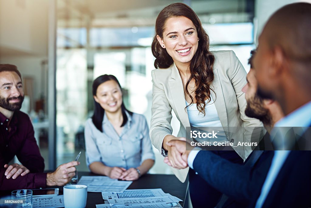 Having a positive attitude is rewarding Cropped shot of two businesspeople shaking hands during a meeting in the boardroom Handshake Stock Photo