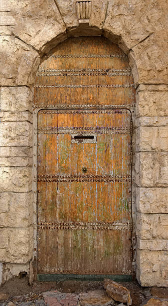 istock Old wooden door in the stone wall 588266154