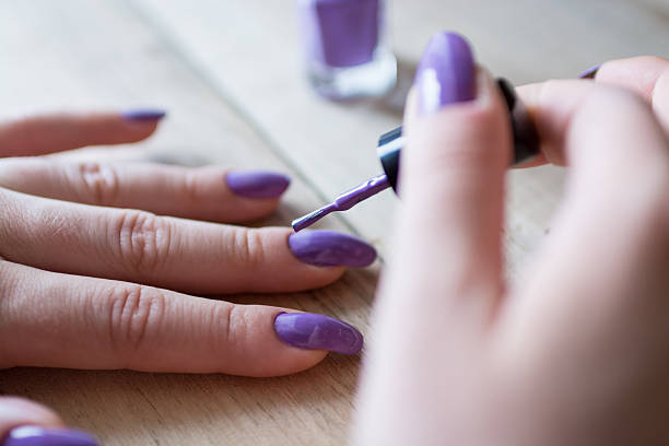 Woman applying nail polish stock photo