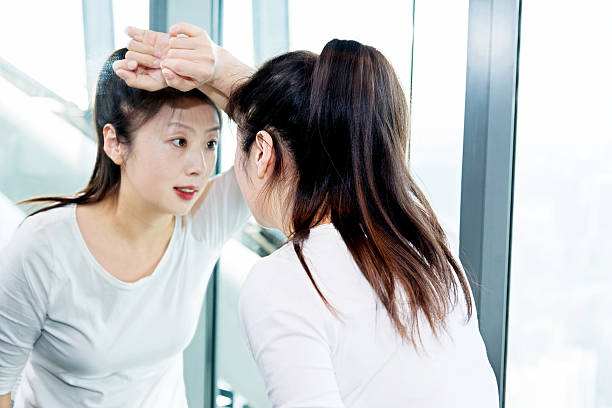 jeune femme pensant dans le miroir - mirror reflection blues glass photos et images de collection