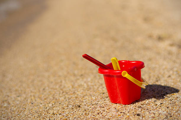 istock Baby bucket on sand 588350490