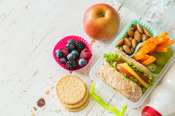 scatola per il pranzo a scuola con libri e matite di fronte - bento foto e immagini stock