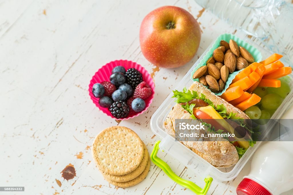 School lunch box with books and pencils in front of School lunch box with books and pencils in front of black board, copy space Lunch Stock Photo