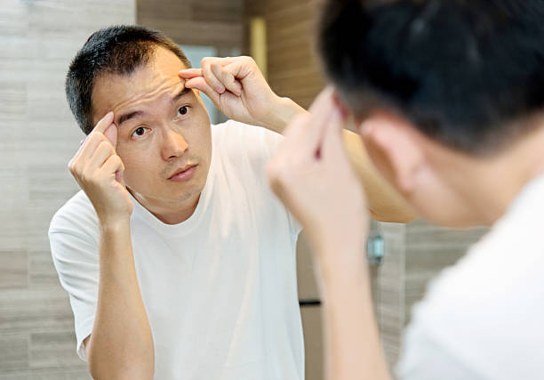 istock Young man morning skin care at bathroom. 588354504