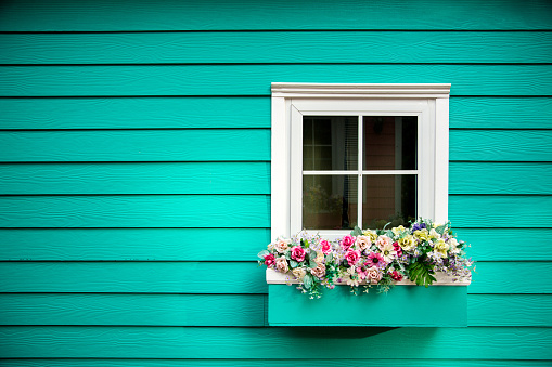 Row of old windows with shutters and flower boxes with geraniums