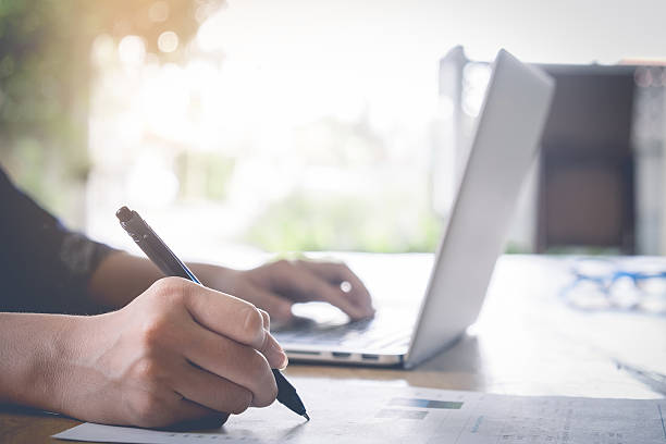 istock Business woman working at the office. analysis document and usin 588356384