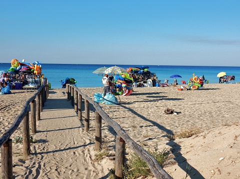 Punta Prosciutto, Porto Cesareo, Lecce, Apulia, Italy - July 21 2016: beach at Riva degli Angeli in the early morning while street vendors allestivano their carts with merchandise to sell to tourists along the beaches.