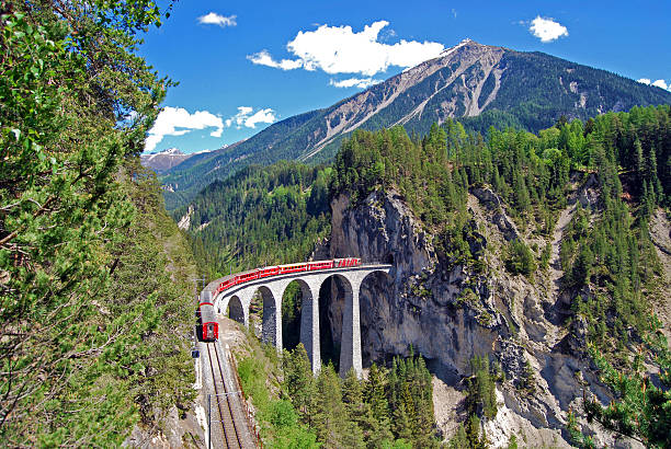Train of the Rhaetian Railway on the Landwasser viaduct. The Landwasser Viaduct is a single track limestone railway viaduct near Filisur in the canton of Graubünden, Switzerland. As part of the Albula line includes the structure  to the UNESCO World Heritage-listed Albula /Bernina Railway. graubunden canton photos stock pictures, royalty-free photos & images