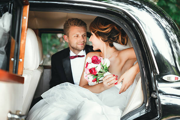 istock Bride and groom sitting in wedding car 588359364