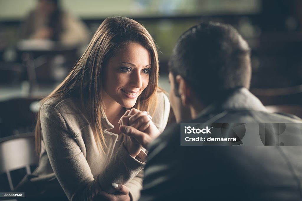 Romantic couple flirting at the bar Romantic young couple dating and flirting at the bar, staring at each other's eyes Love At First Sight Stock Photo