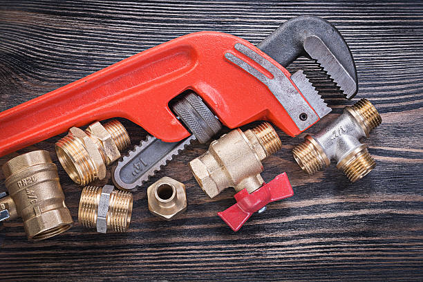 istock Set of plumbing tools on wooden board horizontal view 588366108