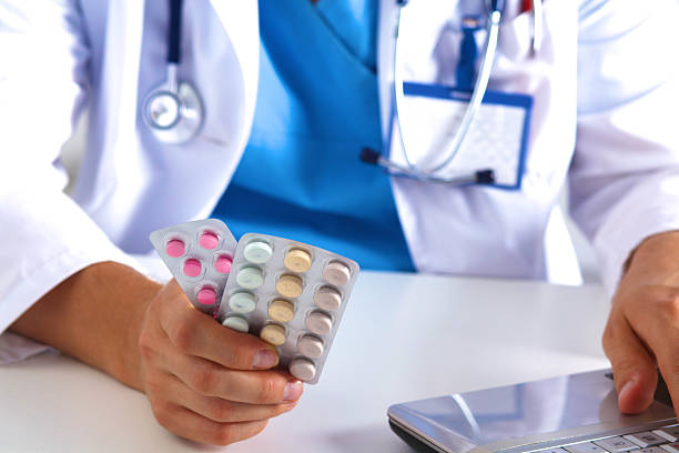 istock the doctor writes a prescription pill on the computer 588366832