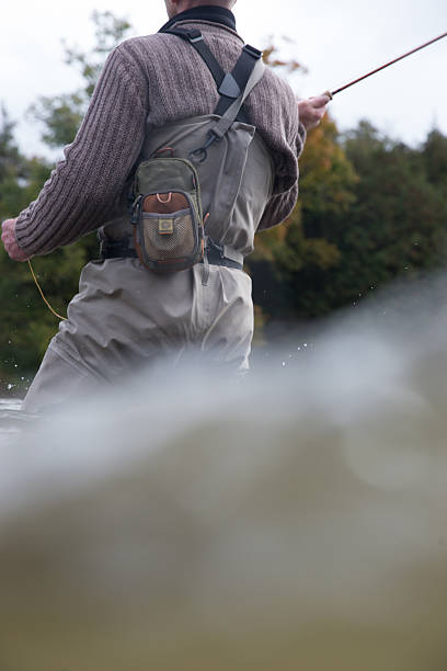 istock Man fly fishing in the fall in a river 588367294