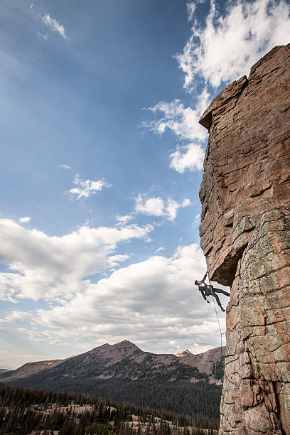 istock Business man climbs rock face 588369220