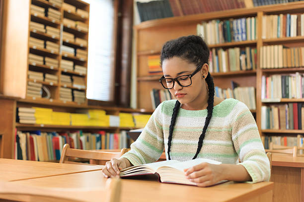 istock Portrait of high school student doing homework at library 588369722